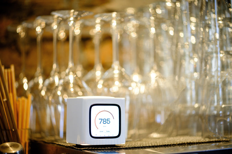 Bitcube on a bar counter in front of wine glasses