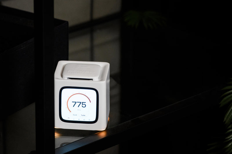 Bitcube glowing on a dark glass shelf at night