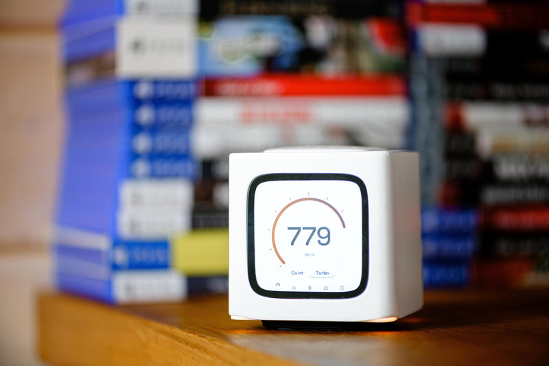 Bitcube on a shelf in front of a row of books